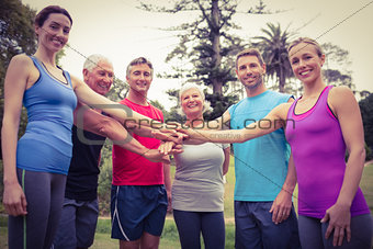 Happy athletic group putting their hands together