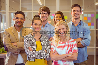 Happy business team smiling at camera with arms crossed