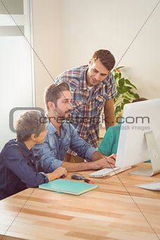 Colleagues using laptop at office