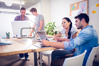 Creative business team gathered around laptops