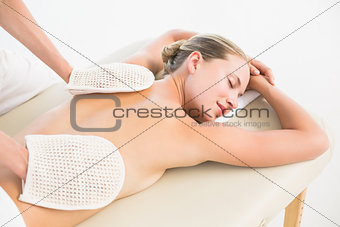 Peaceful blonde enjoying an exfoliating back massage