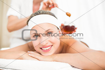 Therapist waxing womans back at spa center
