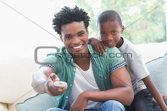 Father and son watching tv together on the couch