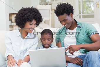 Happy family on the couch with laptop
