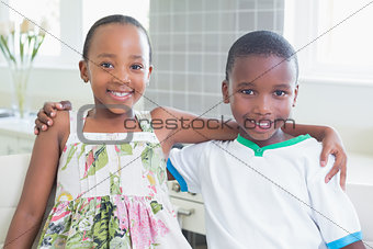 Happy siblings smiling at camera