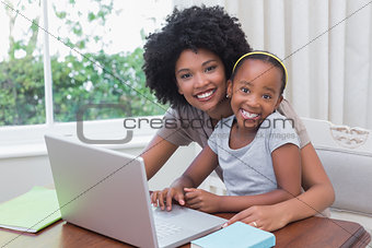 Happy mother and daughter using the laptop