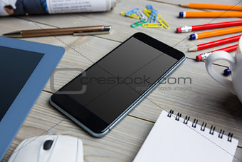 Smartphone next to the cup notepad tablet