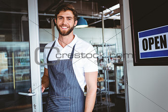 Smiling worker putting up open sign