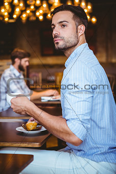 Curious businessman holding a cup of coffee