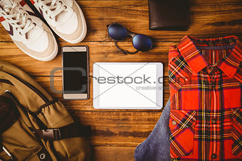 Shirt shoes jean glasses next to wallet smartphone and bag