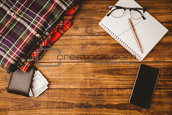 Pen and glasses on notepad smartphone next to shirt