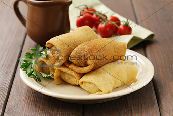 thin pancakes with meat on the plate, Russian cuisine