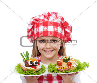Happy little girl chef with creative sandwiches