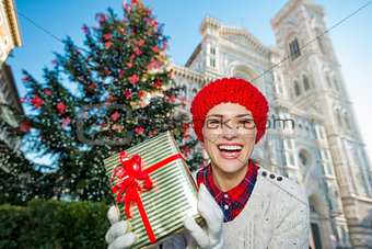Woman tourist with gift standing near christmas tree in Florence