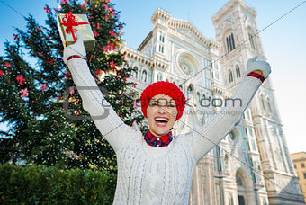 Woman tourist holding gift box near christmas tree in Florence