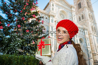 Woman with gift box standing near Christmas tree in Florence