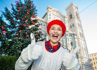 Woman traveler showing thumbs up in Christmas decorated Florence