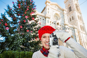 Happy woman traveler making photos of Christmas in Florence