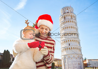 Mother in Christmas hat and daughter checking photos. Pisa