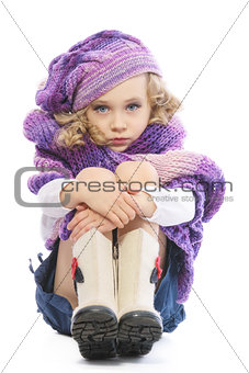 Girl dressed in a bright purple knitted scarf and hat.