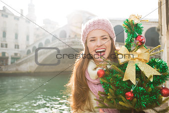Woman with Christmas tree near Rialto Bridge in Venice, Italy