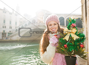 Smiling woman with Christmas tree near Rialto Bridge in Venice