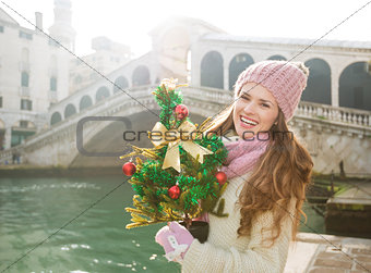 Young woman with Christmas tree near Rialto Bridge in Venice
