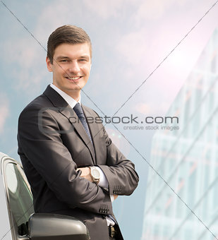 Young businessman standing near his car