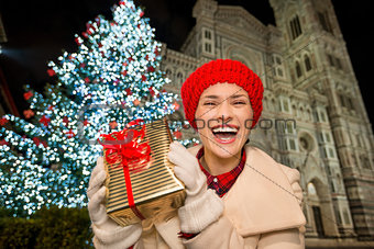 Woman showing gift box near Christmas tree in Florence, Italy