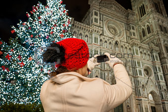 Woman taking photos near Christmas tree in Florence, Italy