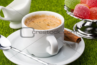 White cup of fresh coffe with dessert