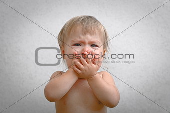 Screaming crying baby covering mouth by hand