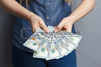 Fan of 100 dollar banknotes in woman hands