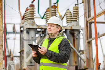Electrical Engineer with folder in electrical substation