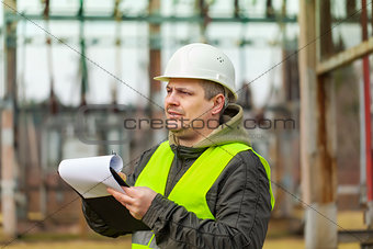 Electrical Engineer with folder in the electric substation
