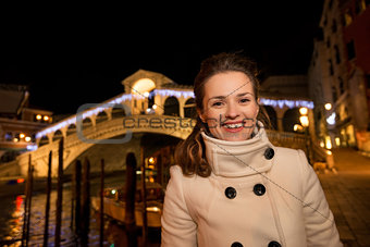 Happy woman standing in front of Rialto Bridge in Venice, Italy