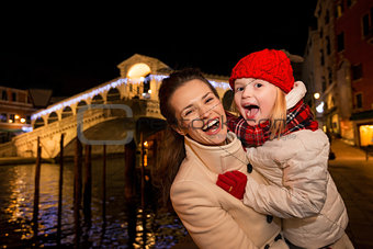 Laughing mother and daughter in Christmas decorated Venice
