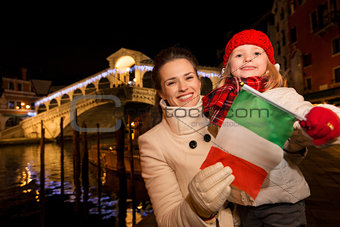 Mother and daughter showing Italian flag in Christmas Venice