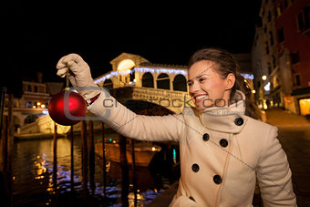 Young woman holding Christmas Ball near Rialto Bridge in Venice