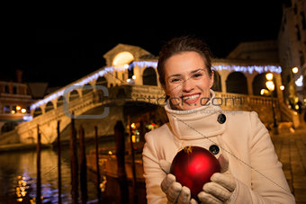 Happy woman with Christmas Ball near Rialto Bridge in Venice