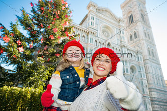 Mother and daughter showing thumbs up in Christmas Florence