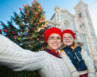 Mother and daughter taking selfie near Christmas tree, Florence
