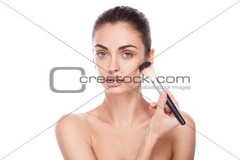 Portrait of woman with makeup brush near her face