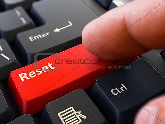 Finger Presses Red Keyboard Button Reset.