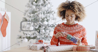 Attractive young woman wrapping Christmas gifts
