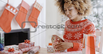 Pretty young woman wrapping Xmas presents