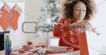 Pretty young woman wrapping Xmas presents