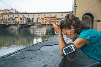 Thoughtful athletic female staying next to Ponte Vecchio bridge