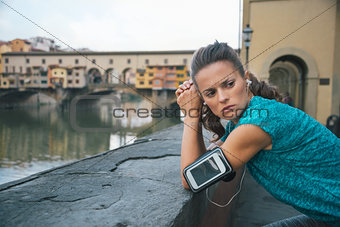Sportswoman with headset staying in front of Ponte Vecchio
