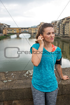 Relaxed fitness woman listening mp3 in front of Ponte Vecchio
